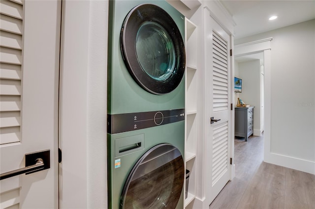 washroom featuring stacked washing maching and dryer and light hardwood / wood-style flooring