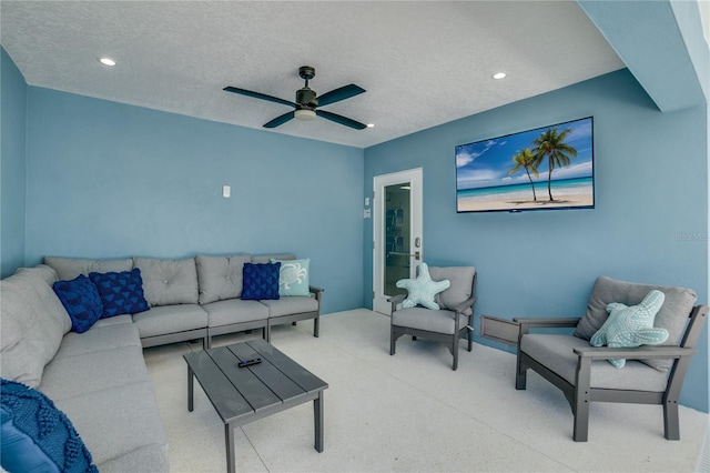 living room featuring a textured ceiling and ceiling fan