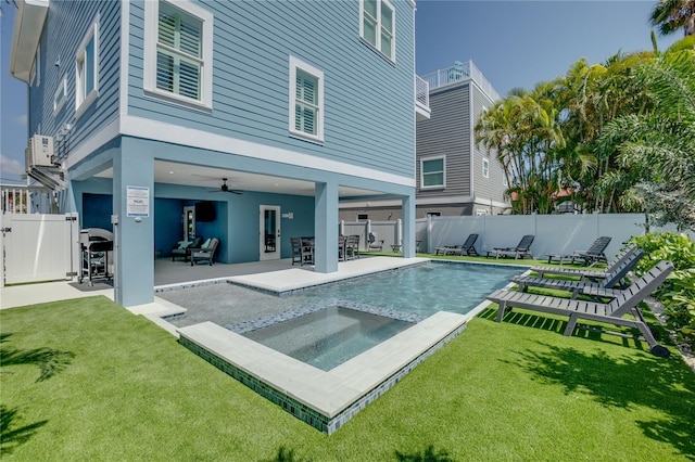 back of house with a pool with hot tub, ceiling fan, a yard, and a patio