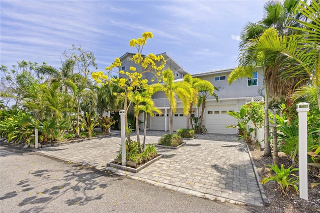 coastal home featuring a garage and decorative driveway