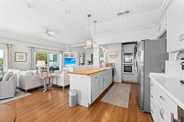 kitchen featuring white cabinetry, stainless steel appliances, light hardwood / wood-style floors, wooden ceiling, and pendant lighting