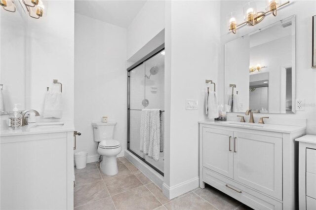 bathroom featuring vanity, walk in shower, toilet, and tile patterned floors