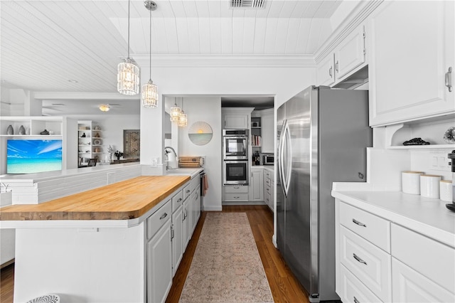 kitchen featuring butcher block countertops, white cabinets, appliances with stainless steel finishes, a center island, and decorative light fixtures