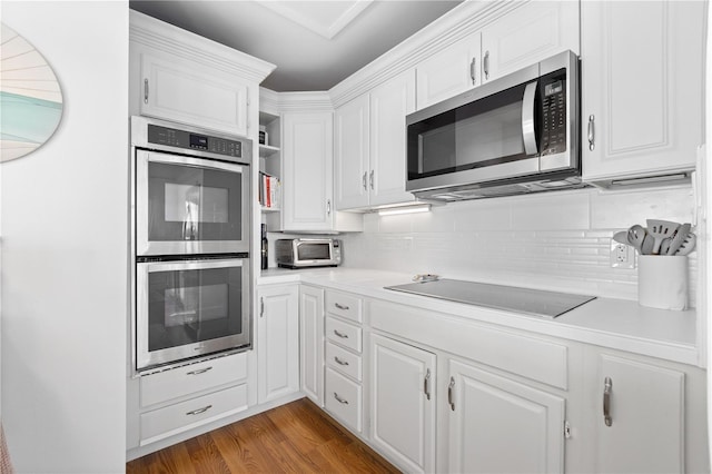 kitchen featuring white cabinetry, decorative backsplash, hardwood / wood-style flooring, and stainless steel appliances