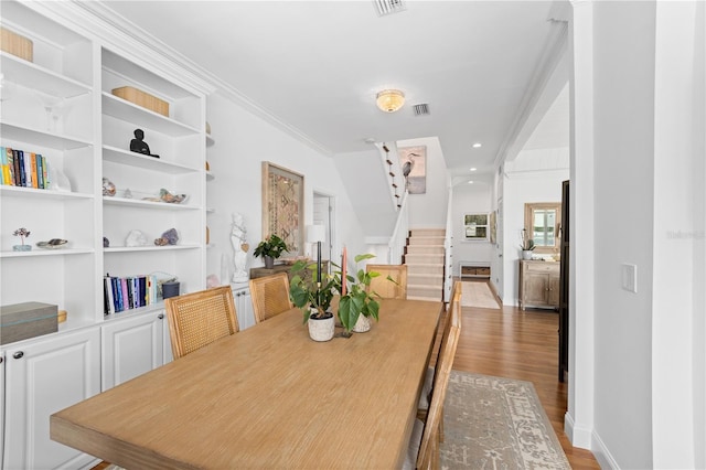 dining room with wood-type flooring and ornamental molding