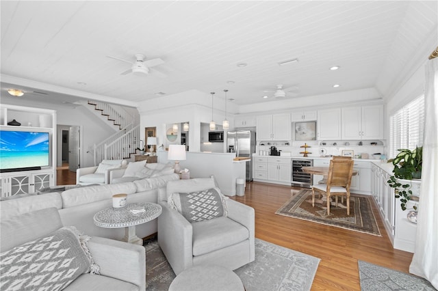 living room featuring beverage cooler, light hardwood / wood-style floors, and ceiling fan