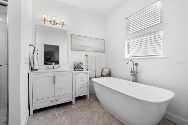 bathroom with vanity, tile patterned flooring, and a tub to relax in