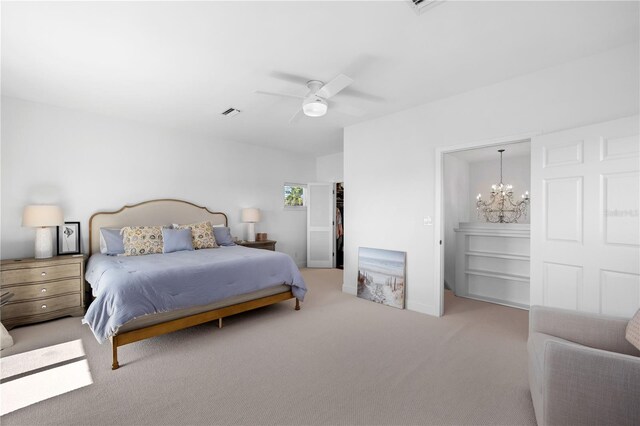 bedroom with carpet floors and ceiling fan with notable chandelier