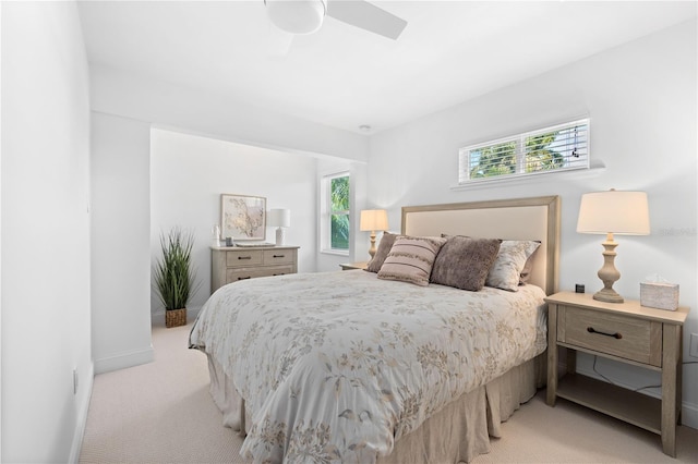 bedroom with baseboards, a ceiling fan, and light colored carpet