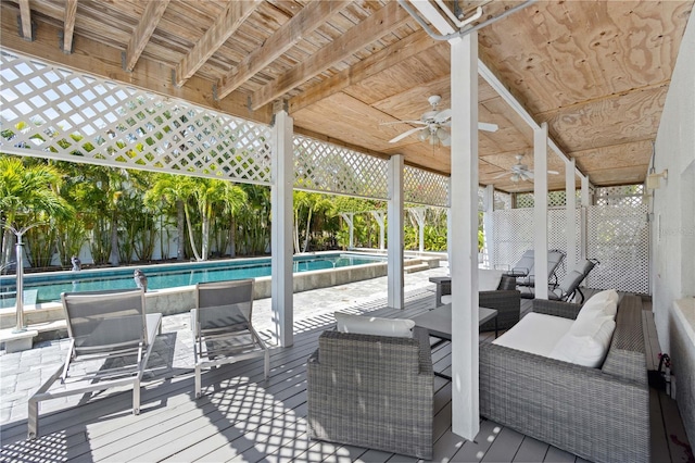 wooden terrace featuring ceiling fan, outdoor lounge area, fence, and a fenced in pool