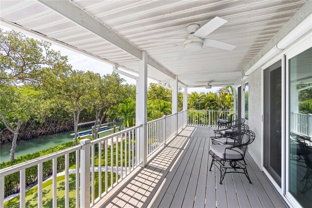 wooden terrace featuring ceiling fan and a lawn