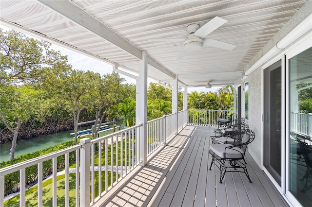 wooden deck featuring ceiling fan, a porch, and a water view