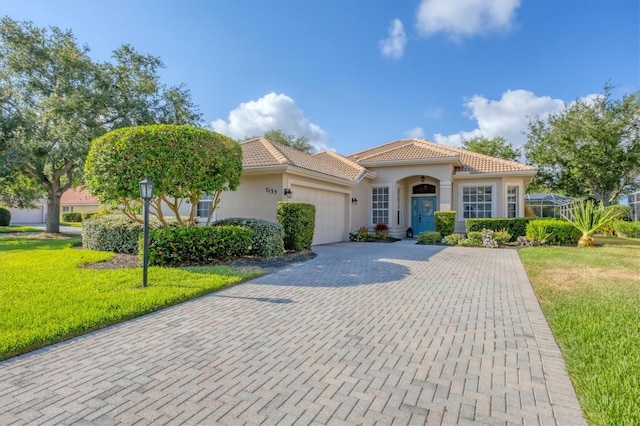 mediterranean / spanish home featuring a front yard and a garage