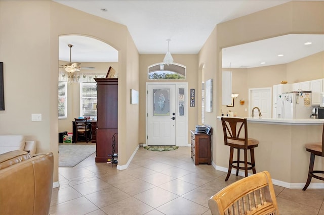 foyer entrance with ceiling fan, sink, and light tile patterned floors