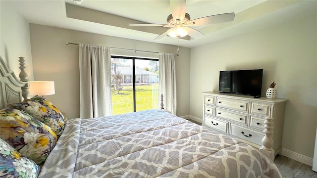 bedroom with ceiling fan, access to outside, and hardwood / wood-style flooring