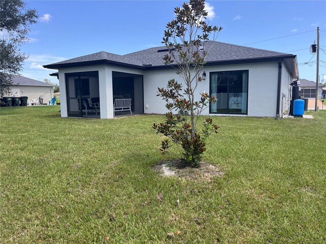 back of house with a lawn