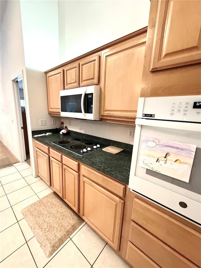 kitchen featuring white appliances, a towering ceiling, and light tile patterned floors