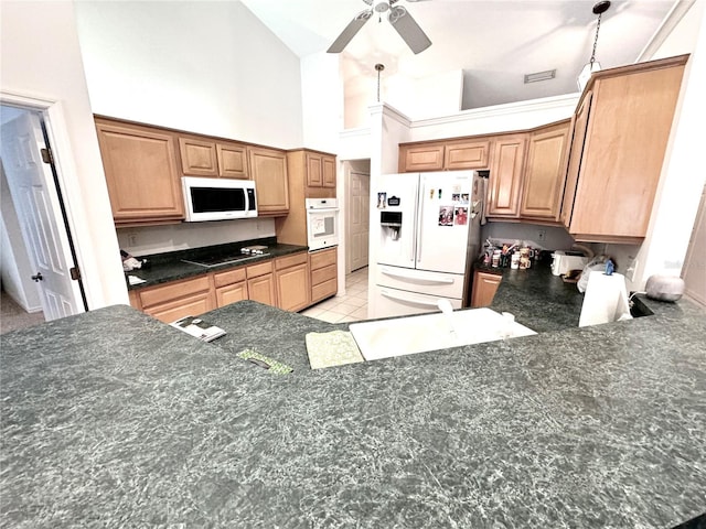 kitchen with sink, white appliances, ceiling fan, high vaulted ceiling, and decorative light fixtures