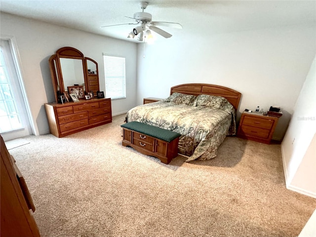 carpeted bedroom featuring multiple windows and ceiling fan