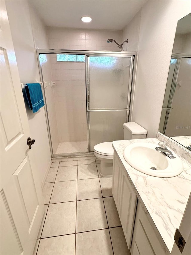 bathroom featuring walk in shower, tile patterned floors, vanity, and toilet