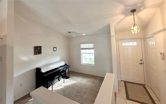 carpeted entryway with ceiling fan