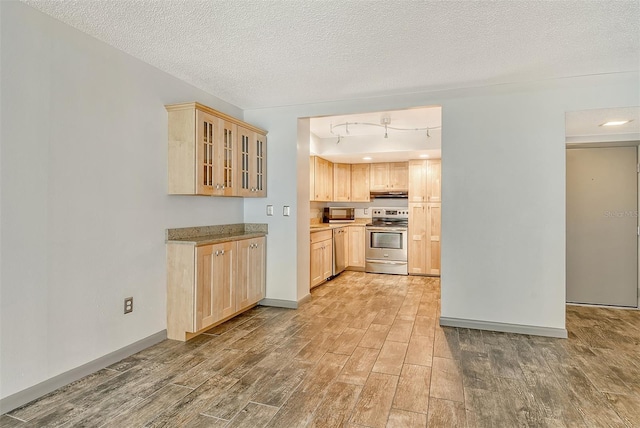 kitchen with light brown cabinets, rail lighting, a textured ceiling, and appliances with stainless steel finishes