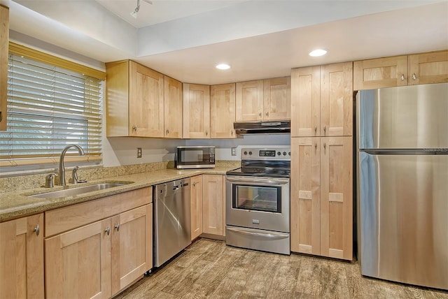 kitchen featuring sink, light hardwood / wood-style flooring, stainless steel appliances, light stone counters, and light brown cabinetry