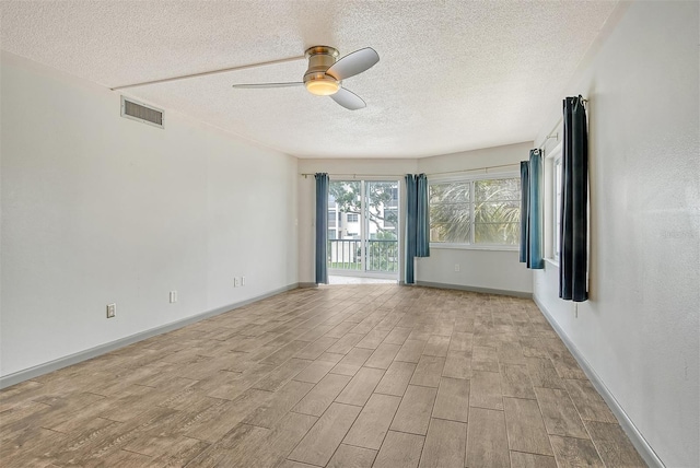 unfurnished room with ceiling fan and a textured ceiling