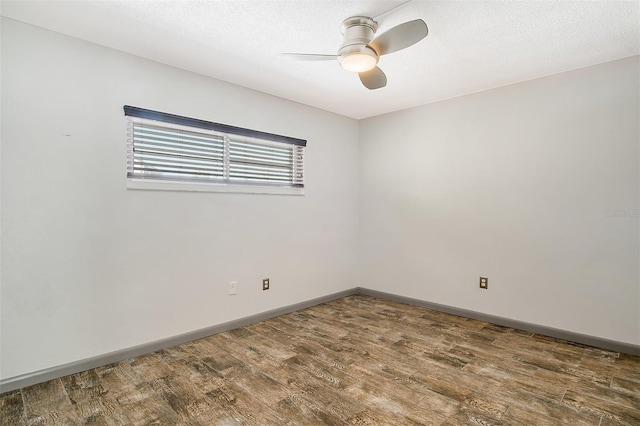 unfurnished room featuring a textured ceiling, dark wood-type flooring, and ceiling fan