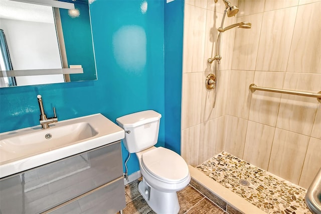 bathroom featuring tiled shower, vanity, and toilet