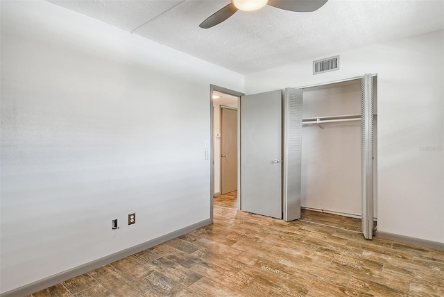 unfurnished bedroom featuring hardwood / wood-style flooring, ceiling fan, a closet, and a textured ceiling