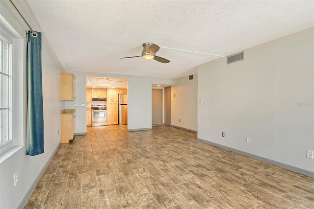 unfurnished living room featuring a textured ceiling and ceiling fan