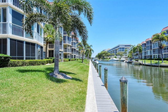 dock area with a water view and a lawn