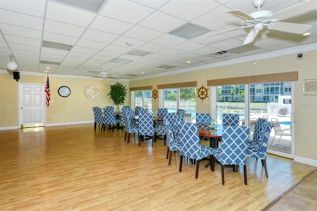 dining area featuring ceiling fan, ornamental molding, a paneled ceiling, and hardwood / wood-style floors