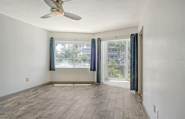 unfurnished room with ceiling fan and a textured ceiling