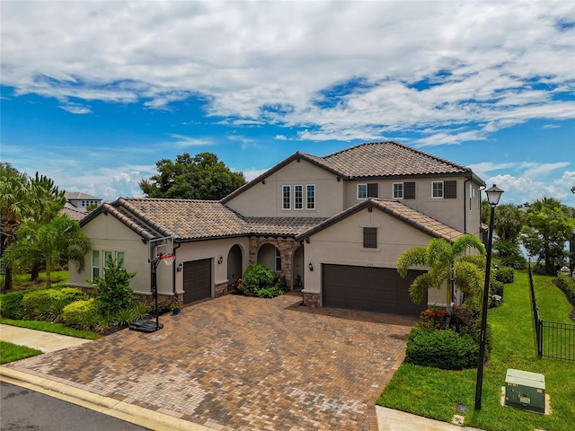 mediterranean / spanish home featuring a front lawn and a garage