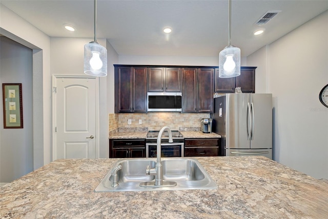 kitchen with decorative light fixtures, sink, backsplash, stainless steel appliances, and dark brown cabinets