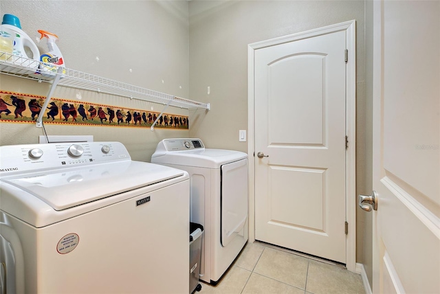 laundry room featuring separate washer and dryer and light tile patterned flooring