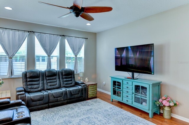 living room featuring hardwood / wood-style flooring and ceiling fan