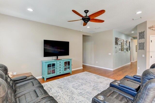 living room featuring wood-type flooring and ceiling fan