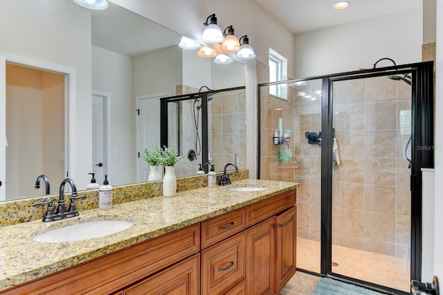 bathroom with a shower with shower door and double vanity