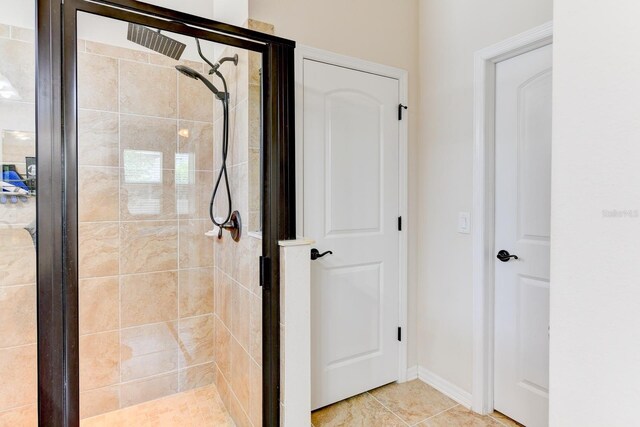 bathroom featuring a shower with shower door and tile patterned flooring