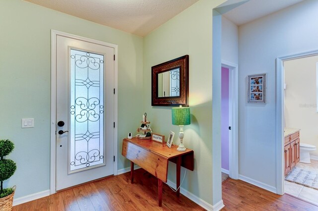 foyer entrance with a textured ceiling and wood-type flooring