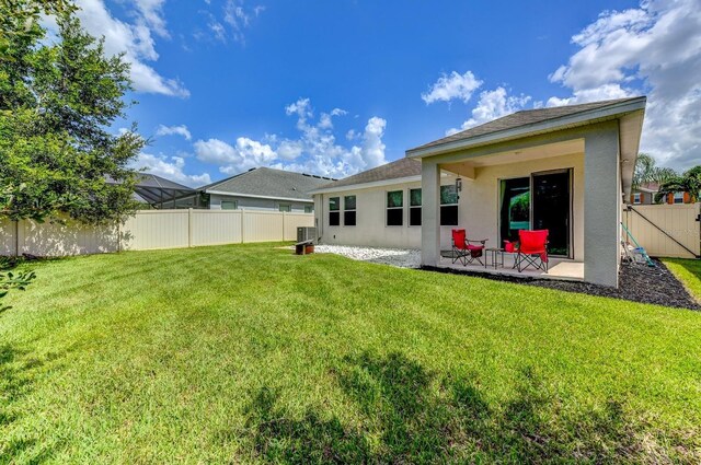 back of house with a patio and a yard