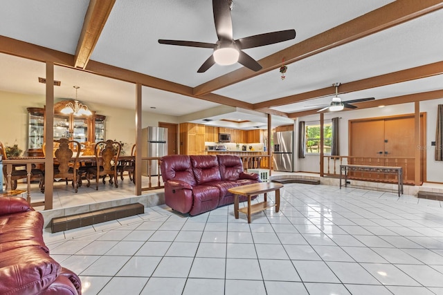 living room featuring beamed ceiling, ceiling fan with notable chandelier, and light tile patterned floors