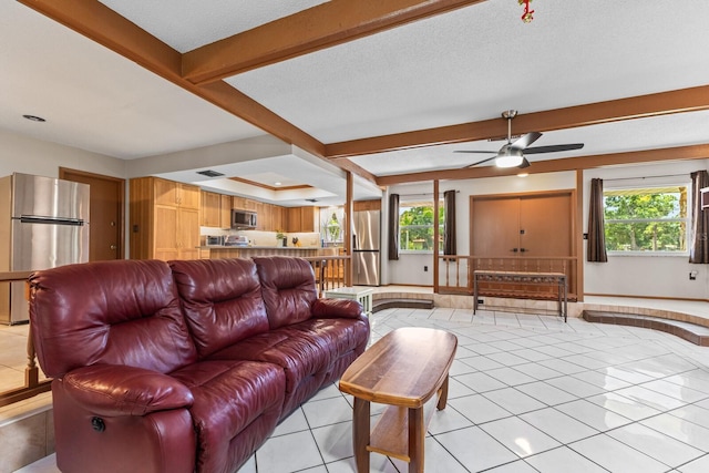 living room with ceiling fan, light tile patterned floors, and a textured ceiling