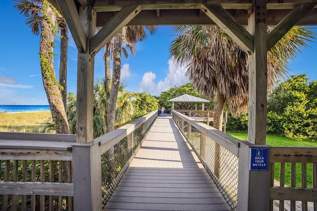 exterior space with a water view, a view of the beach, and a gazebo