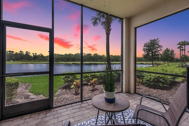 sunroom / solarium featuring a water view