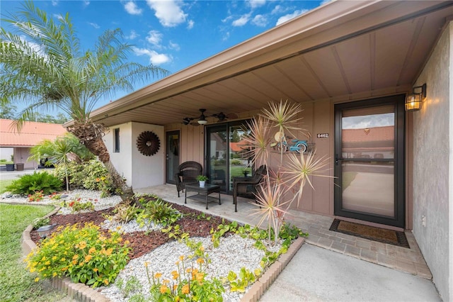 view of exterior entry with a patio and ceiling fan