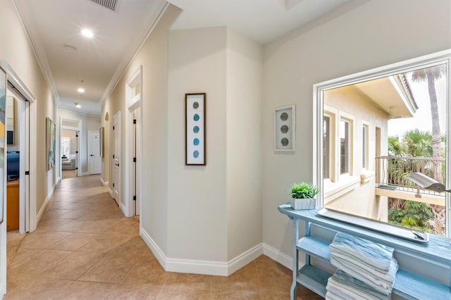 corridor featuring light tile patterned flooring and crown molding